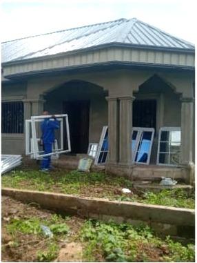 Aluminium window frames staged beside a building under construction