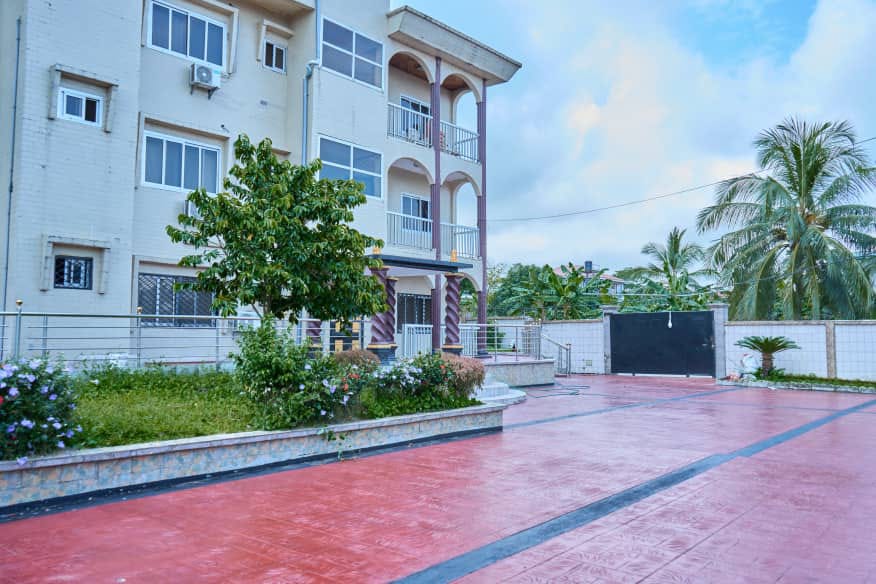Paved compound and garden at the NNANG Group Guest House in Limbe